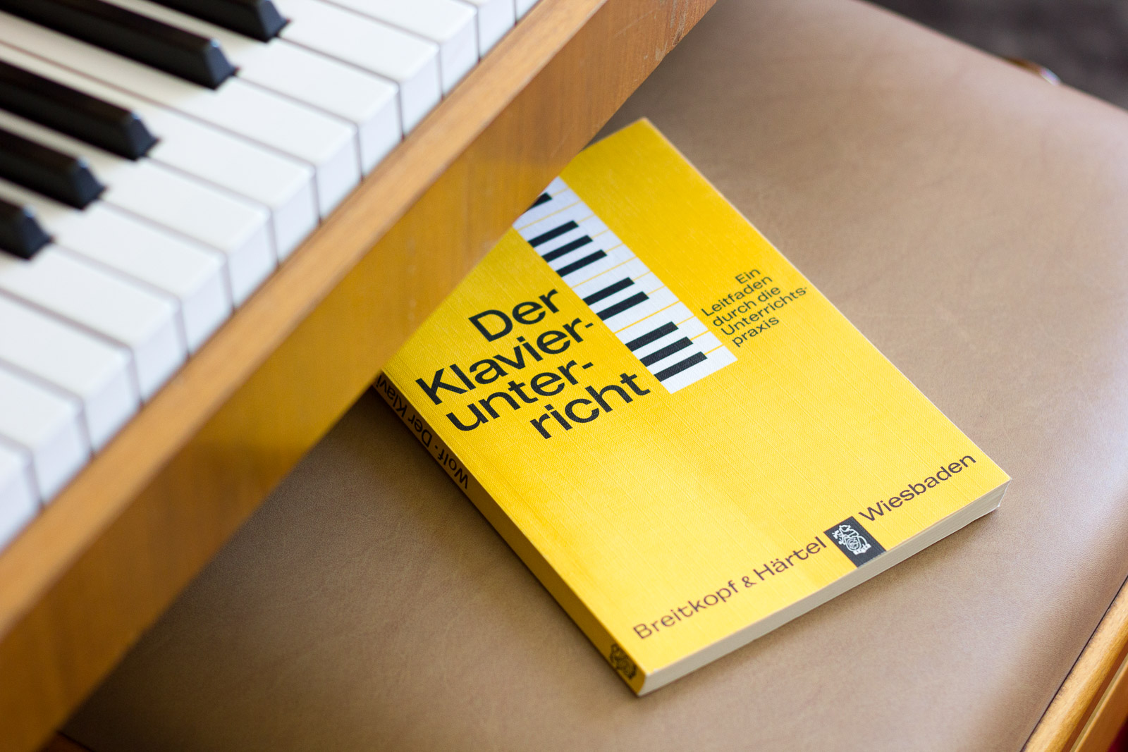 Klavierunterricht: Buch "Der Klavierunterricht" auf Klavierhocker